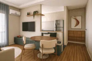 Sala compacta em Campinas com sofá claro, cortina de linho e detalhes em verde – Studio Co.Crie